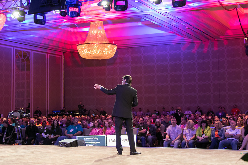 Patrick Combs on stage at Hilton's leadership conference, audience visible